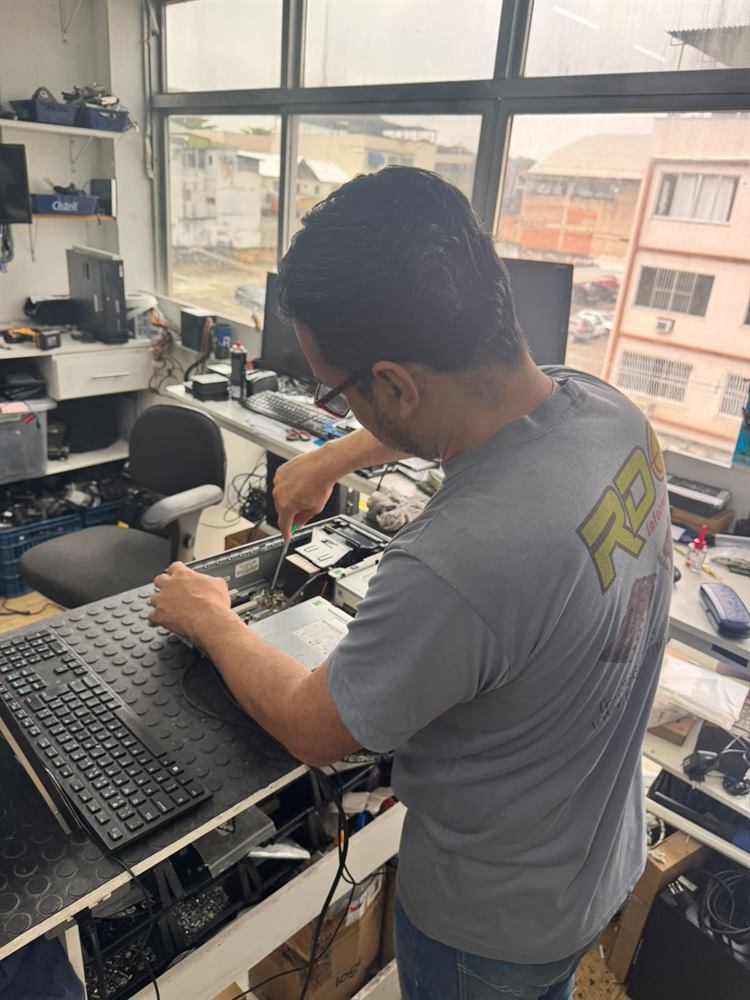 Técnico da RDO Informática fazendo a limpeza interna de um gabinete corporativo na bancada